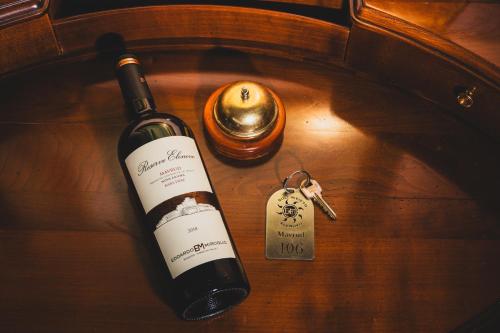 a bottle of wine and a key on a table at Hotel Soli Invicto in Elenovo