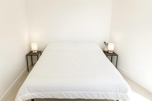 - 2 lits dans une chambre blanche avec 2 lampes dans l'établissement Maison moderne jardin piscine et parking prives, près d'Aix Centre, à Venelles