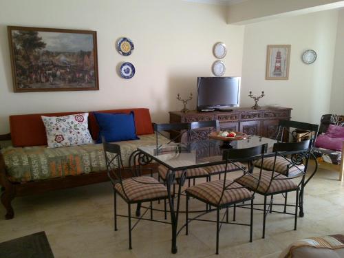 salon z kanapą, stołem i krzesłami w obiekcie Casa das Camélias - I.B.G. HOME w mieście Ericeira