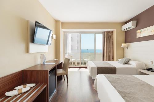a hotel room with two beds and a desk and a television at Hotel Best Indalo in Mojácar