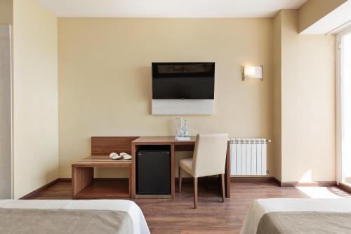 a room with a desk and a tv on a wall at Hotel Best Indalo in Mojácar