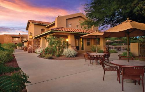 a patio with tables and chairs in front of a house at Wyndham Rancho Vistoso in Oro Valley