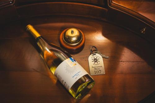 a bottle of wine and a key on a table at Hotel Soli Invicto in Elenovo