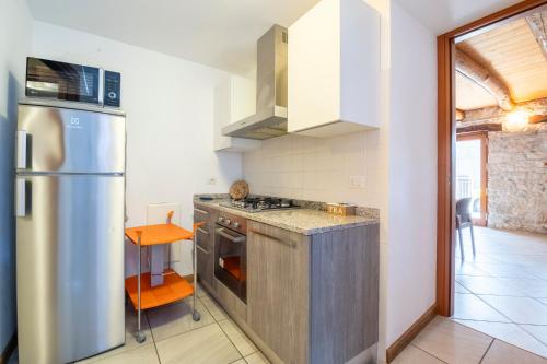a kitchen with a refrigerator and a stove top oven at Albergo Diffuso Balcone sul Friuli in Clauzetto