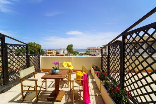 a patio with a table and chairs on a balcony at Hotel La Caletta Village in La Caletta