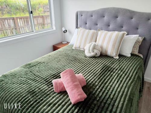 a bed with two towels and a stuffed animal on it at Cozy Stay 4BR Townhouse in Pimpama