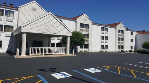 a large white building with a parking lot in front of it at Motel 6-Maryland Heights, MO in Maryland Heights