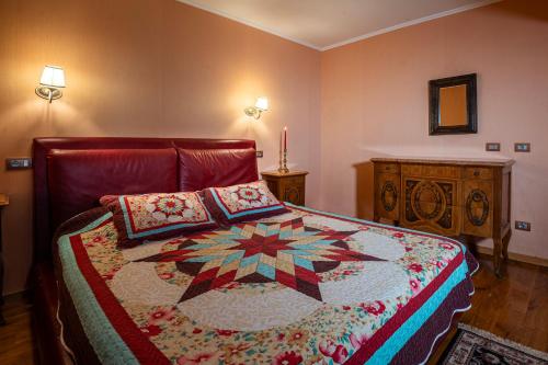 a bedroom with a bed with a quilt on it at Hotel Soli Invicto in Elenovo