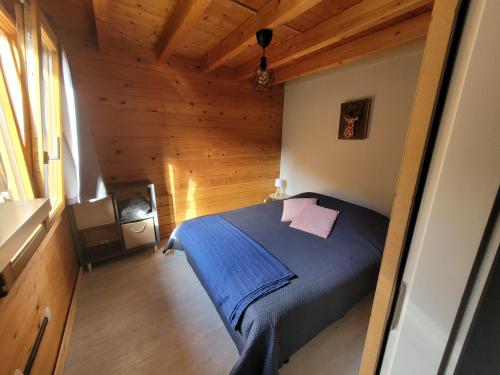 Chalet Chez Marius في لابريس: غرفة نوم مع سرير في كابينة خشبية