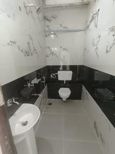 a black and white bathroom with a toilet and a sink at Ranjana Guesthouse in Hampi
