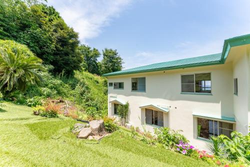 a house with a green roof and a yard at Villa FUN Kawana in Ito