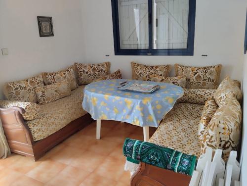 una sala de estar con un sofá y una mesa en Appartement Palm Beach - Mansouria, en Pont Blondin