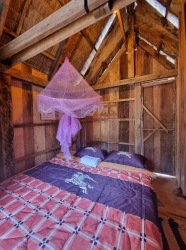 a bed in a room with a roof at Chamka Sne LyLy Resort in Phumĭ Stœ̆ng Chral