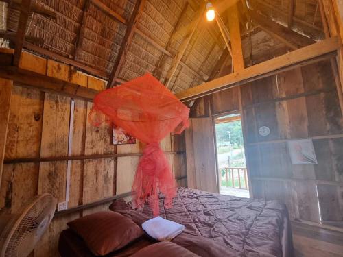 a room with a bed with a red umbrella at Chamka Sne LyLy Resort in Phumĭ Stœ̆ng Chral