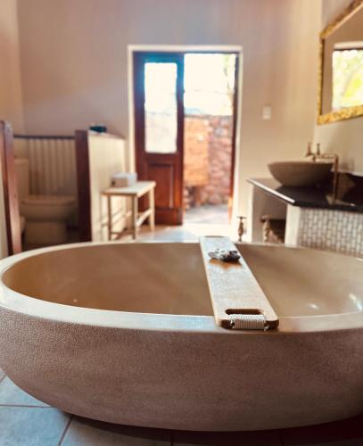 a large bath tub in a bathroom with a sink at Mologa River Lodge in Rust de Winter