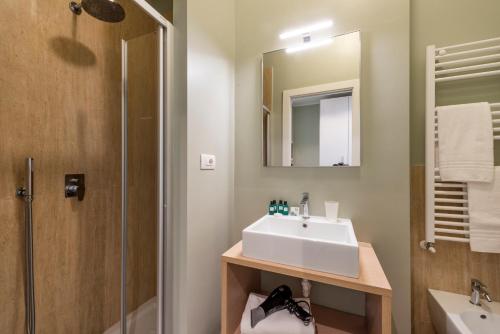 a bathroom with a sink and a shower and a mirror at Duomo Apartments B Home - The Suites in Milan