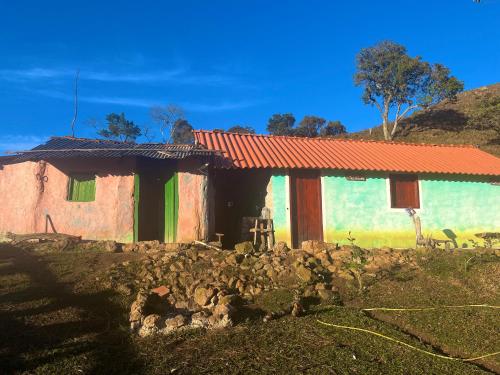 a small house with a stone wall in front of it at Sítio das montanhas in Cunha
