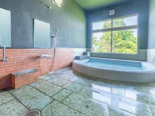 a large bathroom with a tub and a window at Villa FUN Kawana in Ito