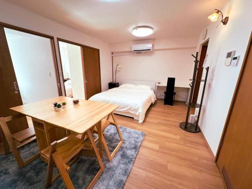 a room with a bed and a wooden table at The Prime Minato 3 Beds Suite Near Tokyo Tower, 2 Mins Walk to Asakusa Line, Direct Access From HND, NRT Airport in Tokyo