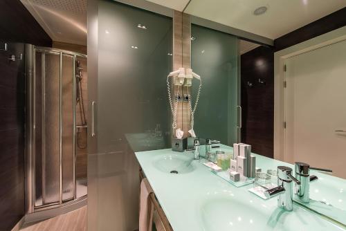 a bathroom with a sink and a shower at Hotel Diagonal Plaza in Zaragoza