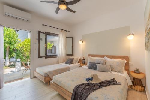 a bedroom with two beds and a ceiling fan at SKYROS AVRA Residences in Skiros