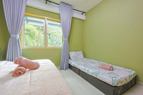 a bedroom with two beds and a window at Modern Family Suite in Cameron Highlands Clover Home K2 in Cameron Highlands
