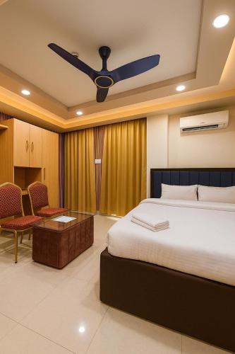 a bedroom with a bed and a ceiling fan at Hotel Ratneswar in Alīpur Duār