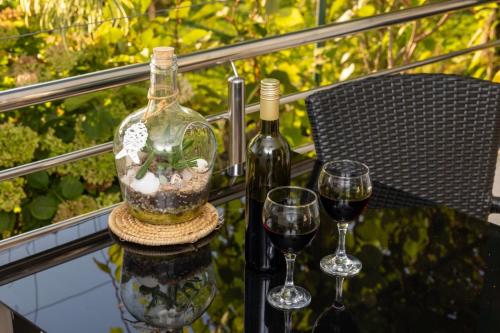a bottle of wine and two glasses on a table at Studio Gita in Promajna