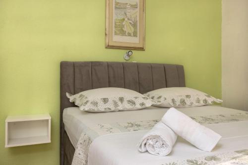 a bed with two pillows in a green bedroom at Studio Gita in Promajna