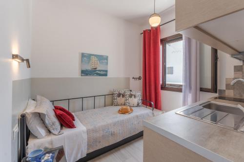 a small bedroom with a bed and a sink at SKYROS AVRA Residences in Skiros