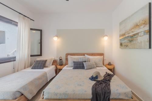 a bedroom with two beds and a large window at SKYROS AVRA Residences in Skiros