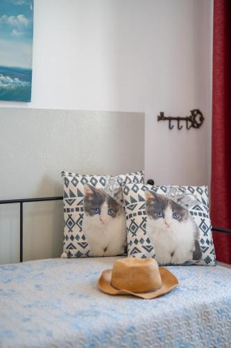 a pair of cats sitting on a bed with pillows at SKYROS AVRA Residences in Skiros