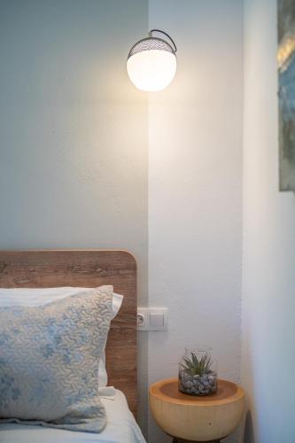 a bedroom with a bed with a table and a lamp at SKYROS AVRA Residences in Skiros