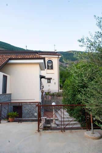 a white house with a fence and a tree at bed and breakfast Grotta dell'Olio in Sarno
