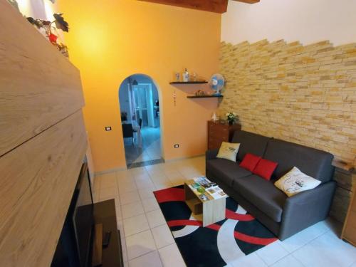 a living room with a couch and a brick wall at Le Grazie in Popoli