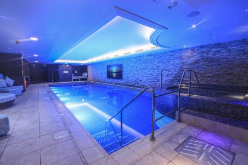 a large swimming pool with a blue lighting at Harbour Hotel & Spa Christchurch in Christchurch