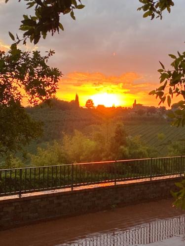 a sunset over a bridge with the sun setting in the background at CasaLeTolfe Residence in Siena