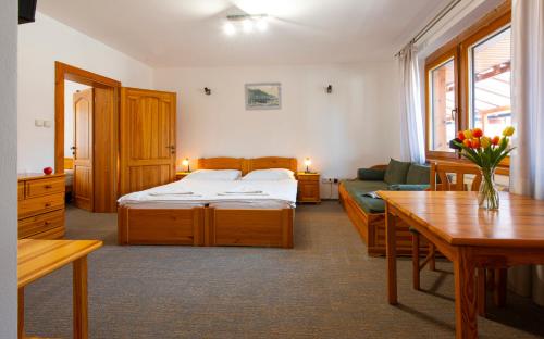 a bedroom with a bed and a couch and a table at Penzion Snezienka in Tatranská Lomnica