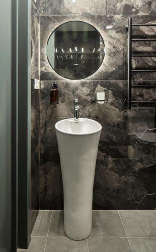 a bathroom with a white sink and a mirror at AREA Hotel Yerevan in Yerevan