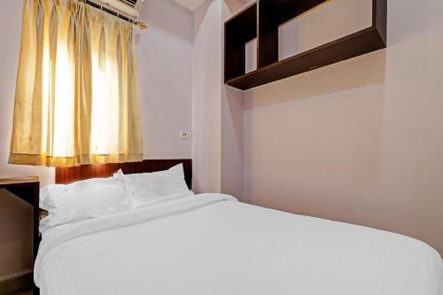 a white bed in a room with a window at Hotel O City Lodge in Dispur