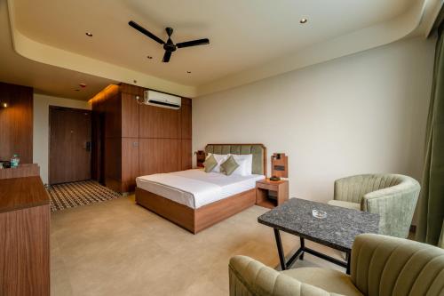 a bedroom with a bed and a table and chairs at Hotel Highway King Neemrana in Neemrana