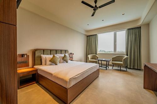 a bedroom with a bed and a large window at Hotel Highway King Neemrana in Neemrana