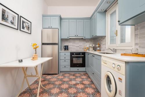 a kitchen with blue cabinets and a washer and dryer at Dafni Local Style, 1 Min from Main Beach in Kardamaina