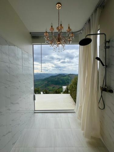 a bathroom with a chandelier and a large window at Cheevavavee Doichang Chiangrai in Ban San Pu Loei