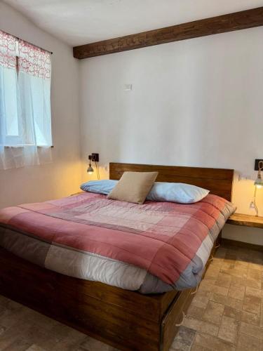 a bedroom with a large bed with a wooden headboard at La casetta di Ninni in Rocca Cinquemiglia