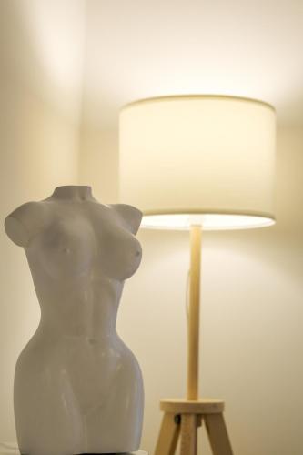a white vase sitting on a table next to a lamp at Cuore di Rocca che diventerà Habemus AD in Rocca di Papa