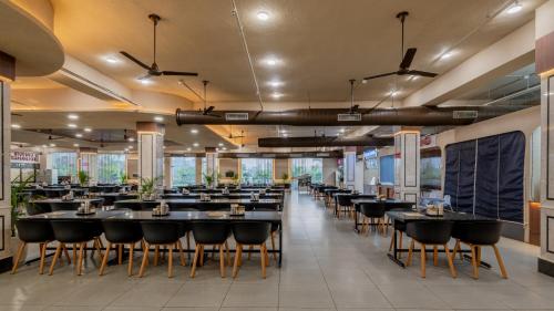 a dining room with black tables and chairs at Hotel Highway King Neemrana in Neemrana