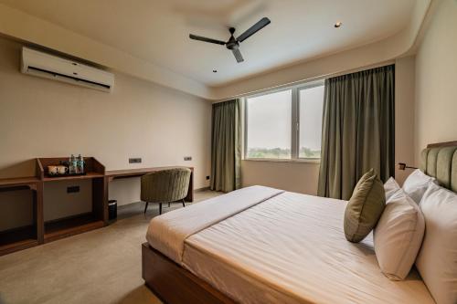a bedroom with a bed with a desk and a window at Hotel Highway King Neemrana in Neemrana