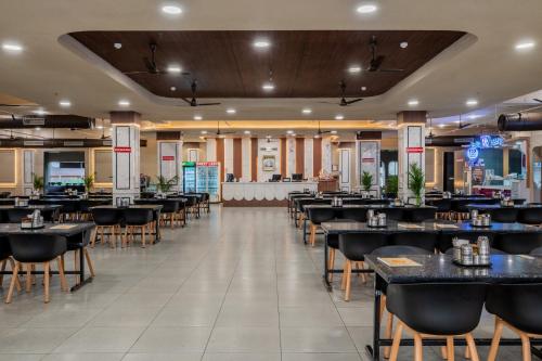 a dining room with tables and chairs in a restaurant at Hotel Highway King Neemrana in Neemrana