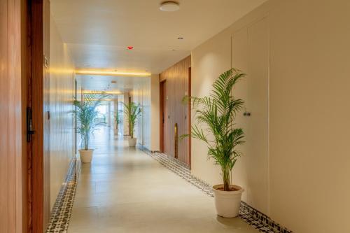 a corridor with potted plants in a hallway at Hotel Highway King Neemrana in Neemrana